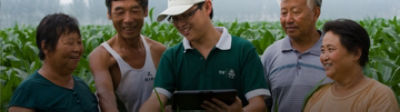 Representative in field with farmers