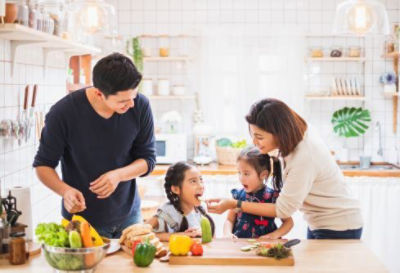 family in kitchen eating vegetables