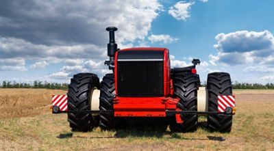 Red tractor in action in a crop field