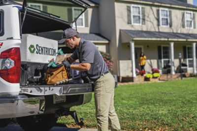 Certified Sentricon Specialist loading bag on back of truck