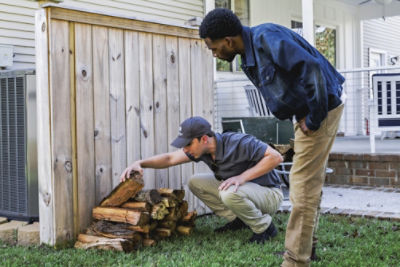 Certified Sentricon Specialist shows homeowner termite activity located in a wood pile
