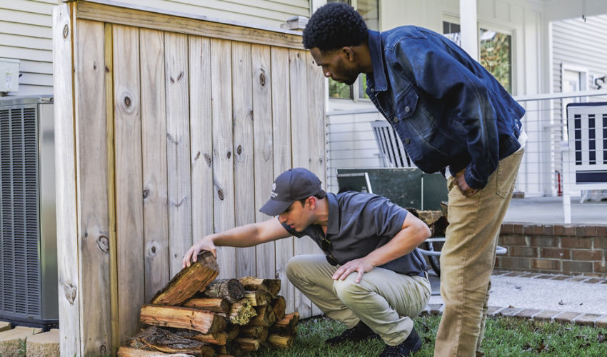 Certified Sentricon Specialist shows homeowner termite activity located in a wood pile