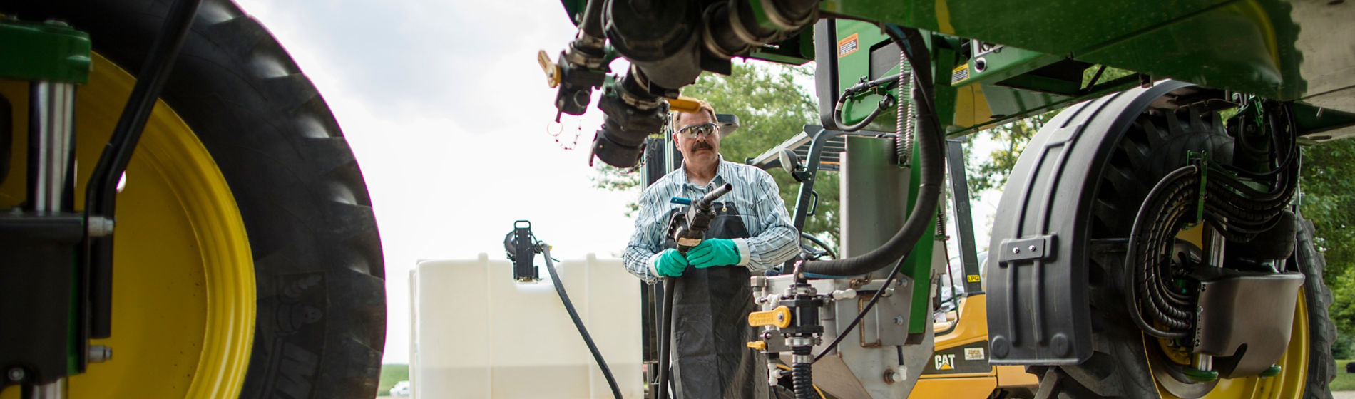 Farmer filling sprayer from Enlist tote