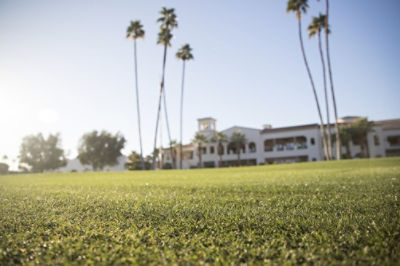 Image of a golf course with a clubhouse in the background