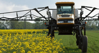 High clearance sprayer going over canola
