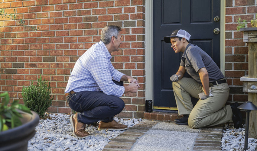 A man kneels next to a Certified Sentricon Specialist and installed 