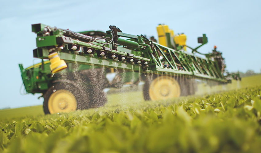 Side view active sprayer in soybean field