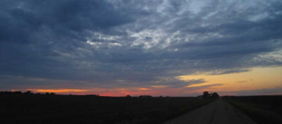 Sunset - clouds and farm machinery in background