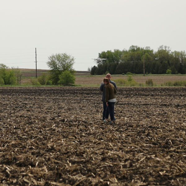Two people in field with drone