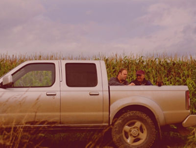 Two men talking at a truck bed