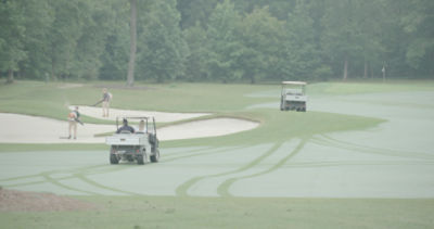 Men preparing sand traps at golf course