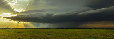 landscape with sun behind dark clouds