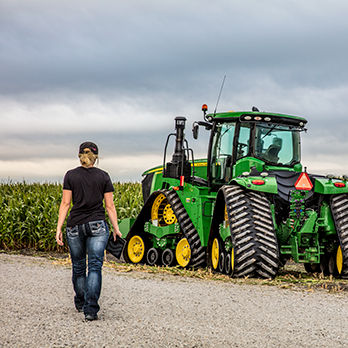 Farmer walking next to green tractor