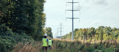 Corteva rep and field worker going through powerline field 