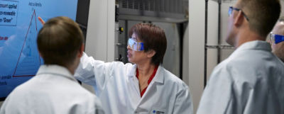 Three people looking at a wall-mounted screen